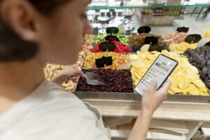 Une femme regarde le nutri score des raisins secs qu'elle s'apprete à acheter