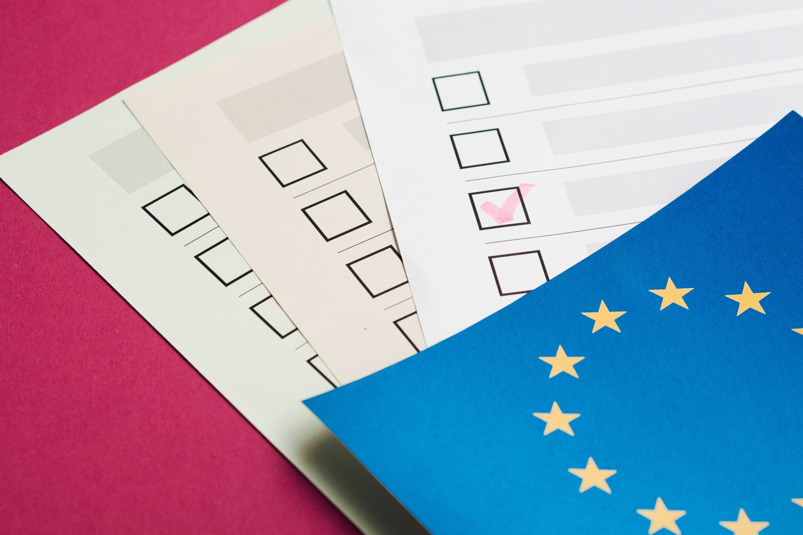 trois feuilles de papier avec des cases à cocher, recouvertes par un drapeau de l'europe