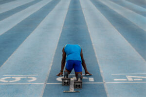 un athlète dans les starting-blocks va s'élancer sur la piste d'athlétisme